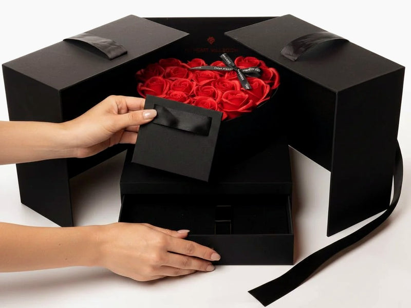 Coffret noir de roses éternelles ouvert entre les mains — cadeau d'anniversaire | Les Roses De Lola