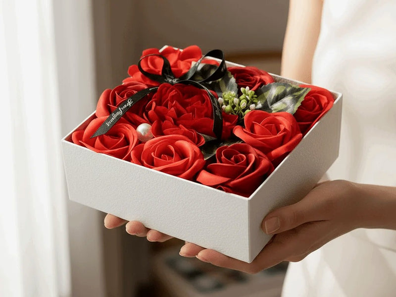 Coffret de roses rouges tendu à deux mains — cadeau pour la famille | Les Roses De Lola